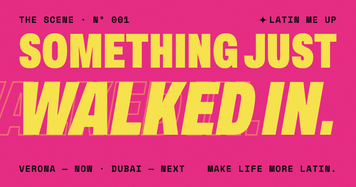 Pink graphic poster. "SOMETHING JUST" in large yellow condensed capitals, then "WALKED IN." in huge yellow italic capitals with a faint outlined copy trailing in from the left edge. Small black text: "The Scene · Nº 001", "LATIN ME UP", "Verona — now · Dubai — next", "Make life more Latin."